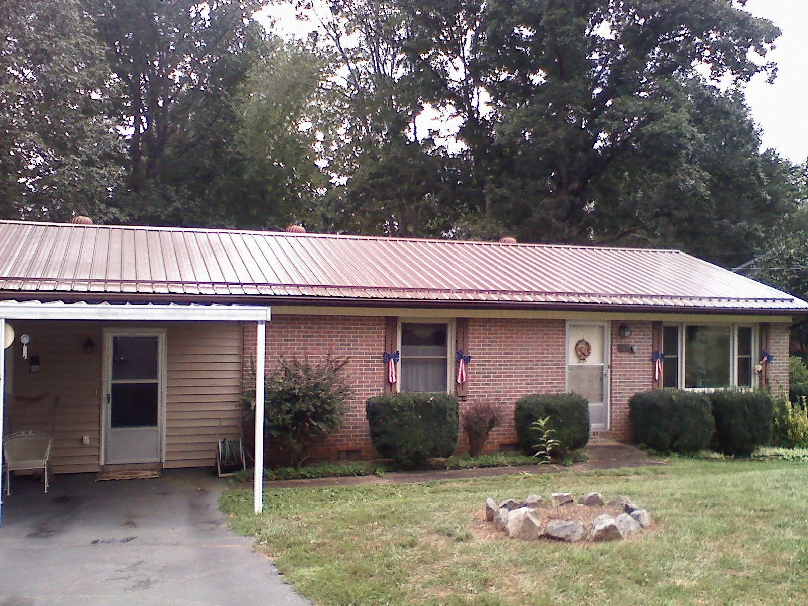 Bronze metal roof and carport on a brick ranch home — Roof Repair work by our crew in Harleyville